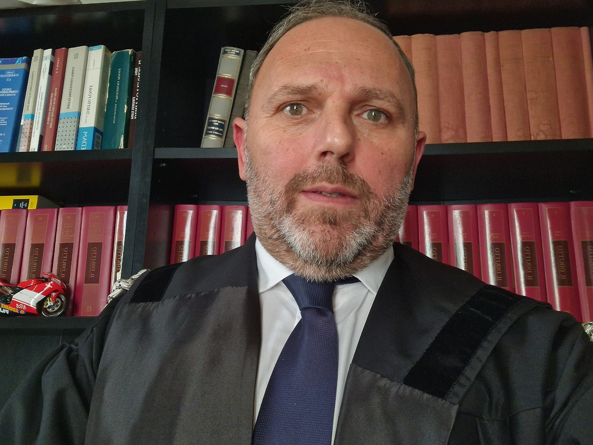 L’Avv. Marco Ippolito in toga, davanti alla libreria dello studio